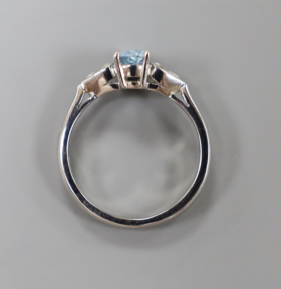 A modern platinum, pear cut aquamarine and two stone pear cut diamond set dress ring, size N, gross weight 5.3 grams